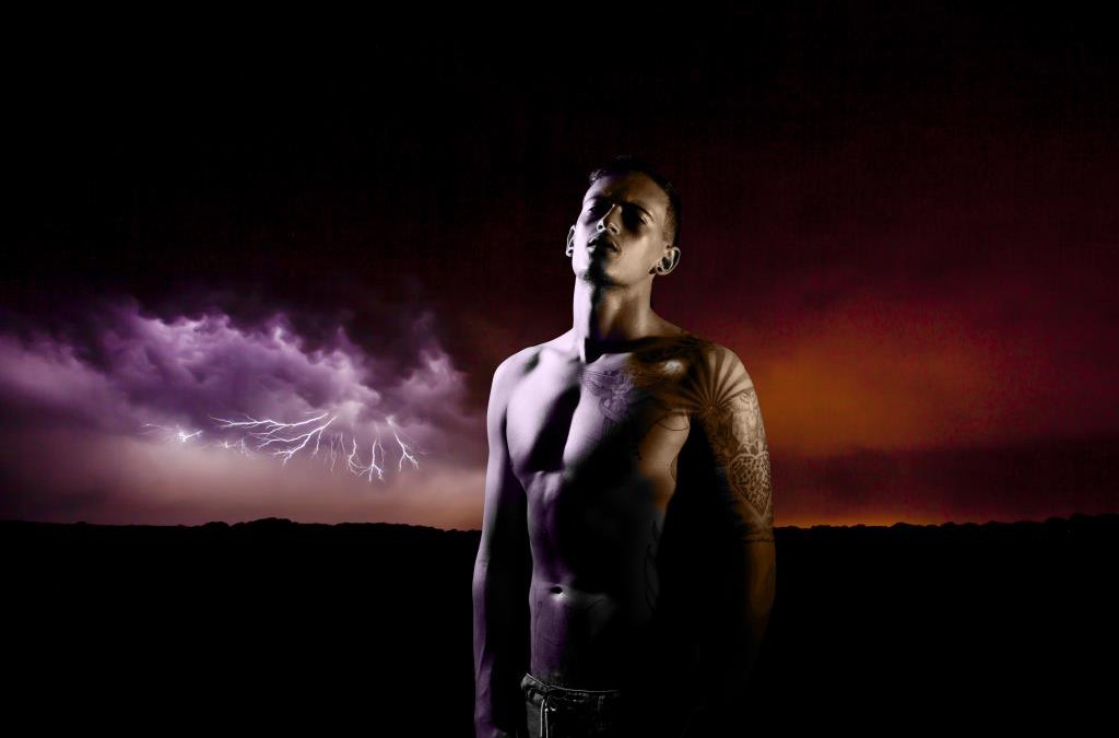 Creative portrait of a strong young man with a lightning storm